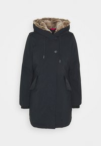 Musta parka-takki, jossa on turkisvuorattu huppu, napit edessä, kaksi sivutaskua ja ribattuja hihasia. Materiaali näyttää sileältä ja kevyeltä.