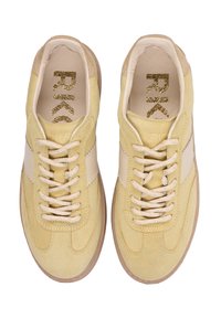 Żółte zamszowe trampki z beżowymi akcentami, płaskimi sznurowadłami i gumową podeszwą. Na językach złote logo oraz teksturowane boczne paski.