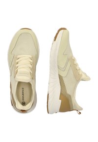 Kreeminsinis sportinių batelių modelis su tekstūruotu audiniu viršuje ir baltu viduriu. Pabrėžia auksinį akcentą ir raištelių užsegimo dizainą.