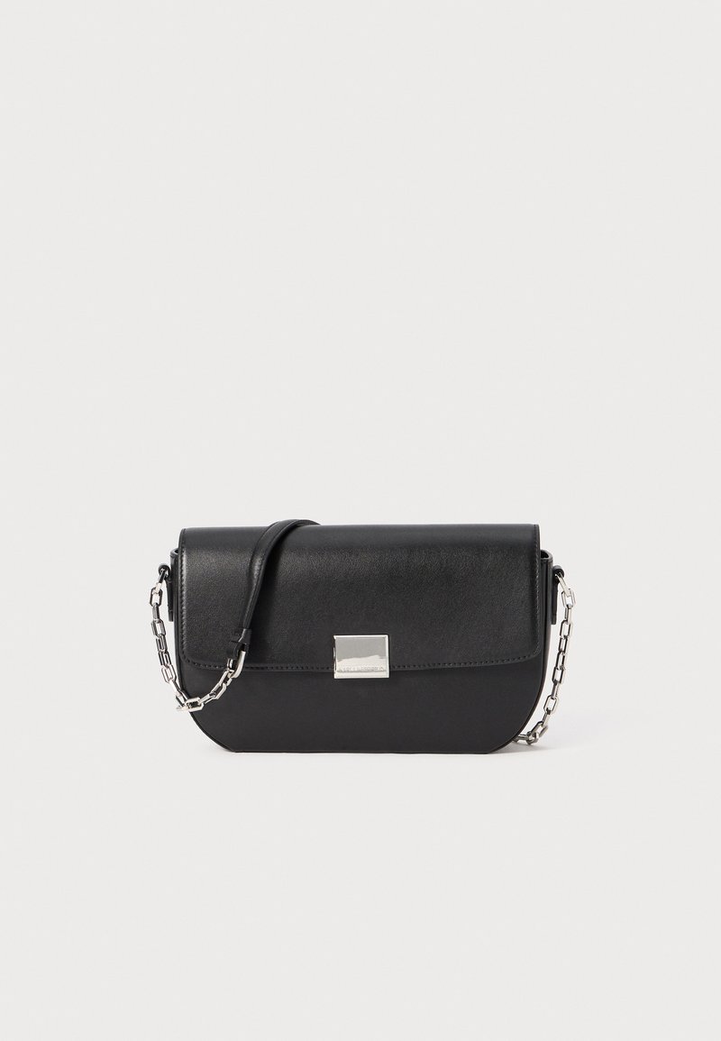 Bolsa de mão em couro preto com forma curvada, alça de corrente prateada e fecho em aba plano. Apresenta um detalhe metálico quadrado na frente.