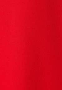 Röd tyg med en slät, något texturerad yta, enhetlig färg och inga synliga mönster eller detaljer.