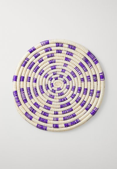 Round woven mat in cream with purple accents, featuring concentric circular patterns and a textured surface.