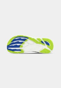 Semelle de chaussure présentant une base blanche avec des motifs de traction en caoutchouc verts et bleus, des rainures texturées et une finition lisse.