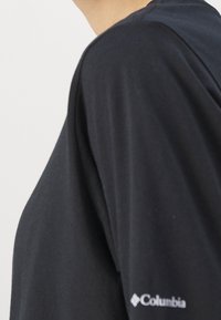 Svart kortärmad t-shirt i mjukt tyg. Har en rund halsringning och en vit Columbia-logga på vänster ärm.