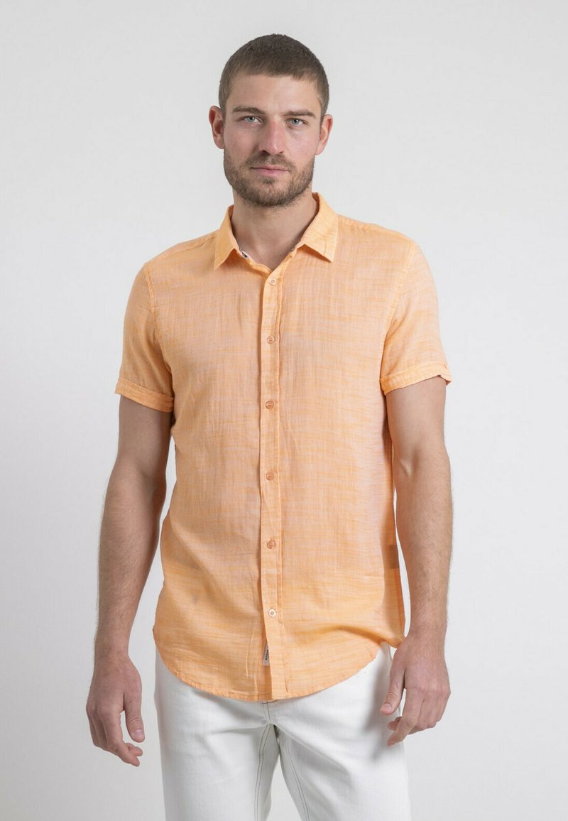 Chemise à manches courtes, boutonnée, en lin orange clair avec une finition texturée, ourlet arrondi et une poche poitrine unique.