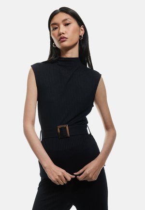 Top noir à côtes avec un col montant et sans manches. Présente une large ceinture avec une boucle rectangulaire. Texture lisse, silhouette ajustée.