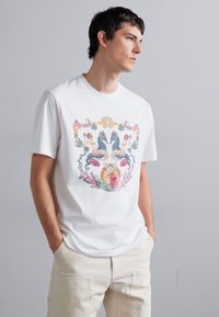 Witte katoenen t-shirt met een kleurrijk grafisch ontwerp van zeemeerminnen en een schelp, ronde hals, korte mouwen en een ontspannen pasvorm.
