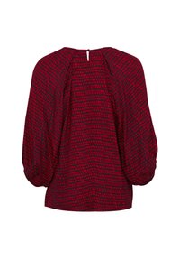 Rød mønstret bluse med en tekstureret design, puffede ærmer og en nøglehulåbning bagpå. Stoffet virker let og svævende.