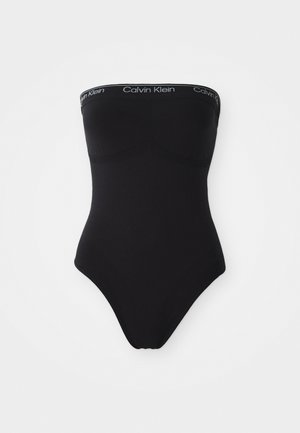 Svart stroppeløs badedrakt med sømløst design. Har et elastisk bånd med Calvin Klein-merke øverst og høy utskjæring på benåpningene.
