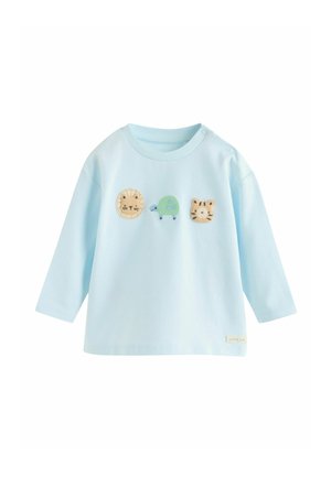 Helehall sinine pikkade varrukatega särk, millel on ümmargune kaelus ja kolm tikitud loomamotiivi: lõvi, kilpkonn ja tiiger. Pehme kangapinna tekstuur.