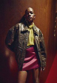 Veste en cuir marron, blouse jaune à volants, jupe en satin rose. Texture lisse et couleurs contrastées avec des formes audacieuses et un design ajusté.
