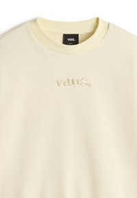 Sudadera de cuello redondo amarilla clara, hecha de tejido suave, con un logo "vans." bordado en el centro. Textura suave, corte relajado.
