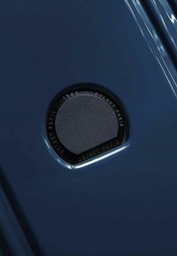 Accessorio da viaggio Delsey Paris in navy, con una patch rotonda nera con testo in rilievo. Superficie liscia con finitura lucida.