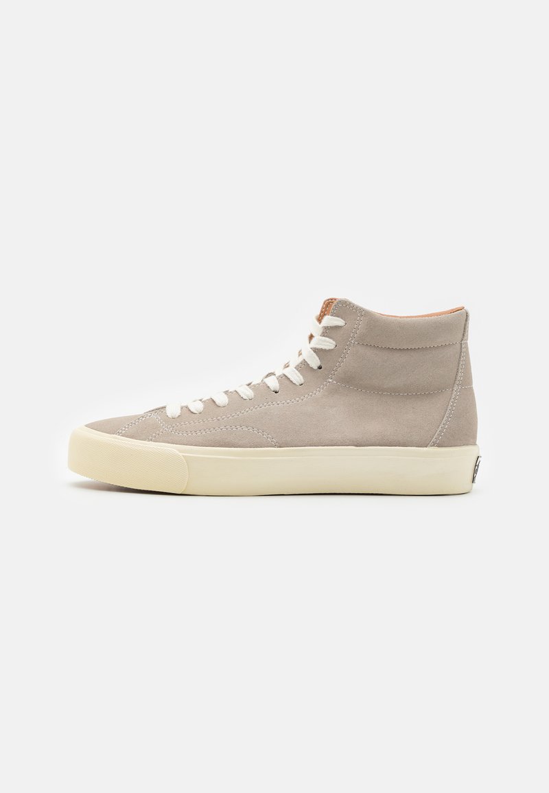 Høye sneakers i lys grå fløyel. Gummisåle, hvite snørebånd og brune detaljer ved kragen og tungen. Enkle sømmer.