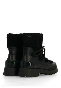 Černé kotníkové boty kombinující hladkou kůži a měkkou textilii. Mohutná černá podrážka a kulatá špička, se šněrováním a akcenty s logem.