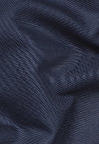 Mörkblått tyg med en texturerad, vävd mönster som visar subtila variationer i nyans och en mjuk, flexibel fall.