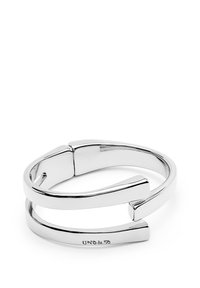 Bracelet ouvert en argent au design moderne et minimaliste, avec "UNO de 50" gravé sur la bande inférieure.