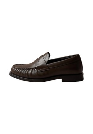 Donkerbruine leren loafer met een gestikte moc toe en lage zwarte zool, zijaanzicht op een witte achtergrond.