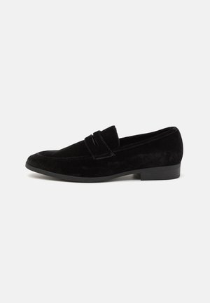 Black suede loafers with a flat heel and vamp accent. Features smooth texture and classic design. Suitable for formal or casual wear.