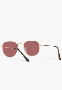Occhiali da sole con lenti rosa a forma ottagonale, sottile montatura in metallo dorato e terminali delle astine in plastica nera. Nota doppia ponte e naselli trasparenti.
