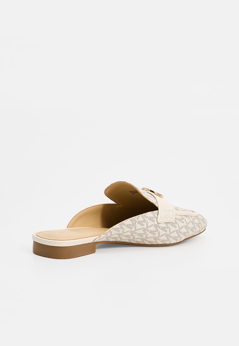 Beige instappers met een textuur met een geometrisch patroon, voorzien van een platte zool en een voorste bandaccent voor extra detail.