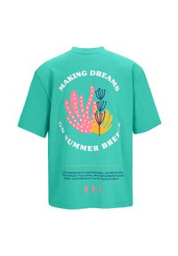 Turquoise t-shirt met korte mouwen, gekenmerkt door een kleurrijk grafisch ontwerp op de achterkant met tekst, koraalvormen en zeepaardaccenten aan de onderkant.