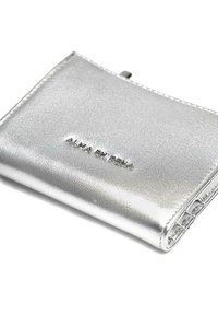 Cartera metálica plateada de textura suave, con el texto en relieve "ALMA EN PENA." Diseño compacto con cierre plegable.