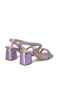 Paarse sandalen met hakken en een metallic afwerking, voorzien van kruislings over elkaar lopende banden versierd met strass en stevige blokhakken.