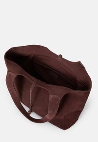 Καφέ σουέτ τσάντα tote με απαλό υφή, ανοιχτό πάνω μέρος και διπλές λαβές. Διαθέτει εσωτερική τσέπη και μινιμαλιστικό σχέδιο.