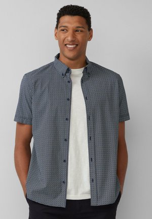 Korte mouwen, knoopsluiting shirt in marineblauw met een geometrisch patroon, gemaakt van geweven stof. Gekocht over een wit T-shirt, met een kraag.