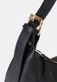 Borsa a tracolla in pelle nera con finitura testurizzata, caratterizzata da una fibbia e dettagli della cerniera in tono dorato. La tracolla ha fori per la regolazione della lunghezza.