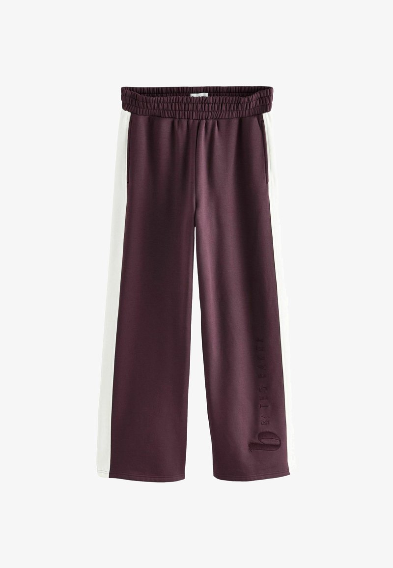 Bordeaux brede broek met witte zijpanelen, elastische tailleband en reliëf logo detail op de linkerpijp. Glad, zacht materiaal.
