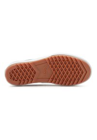 Suela de zapato Vans con una goma naranja que presenta un patrón de diamante, diseñada para proporcionar tracción, y un borde blanco para el contraste.