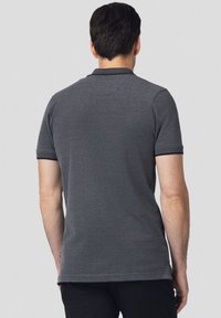Grafitowa koszulka polo z krótkim rękawem, z teksturowanym kołnierzykiem i kontrastowymi mankietami. Prosty design, minimalne logo z tyłu.