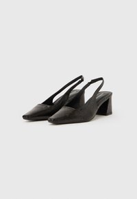 Black slingback heels with a pointed toe, textured surface, and a block heel. Features a slim strap for secure fit.