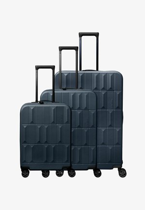 Tres maletas rígidas de color azul oscuro con asas telescópicas y cuatro ruedas giratorias, dispuestas de la más pequeña a la más grande.