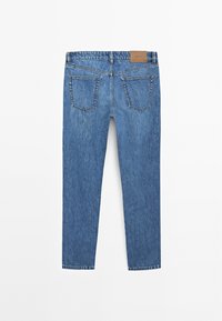 Jean en denim bleu avec une coupe droite, cinq poches et une étiquette en cuir beige à la taille. Décoloration légère visible sur le tissu.