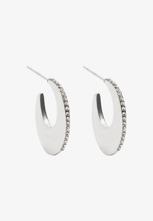 Srebrne kolczyki w kształcie obręczy o gładkim, zaokrąglonym wzorze, z rzędem małych przezroczystych cyrkoni wzdłuż jednej krawędzi.