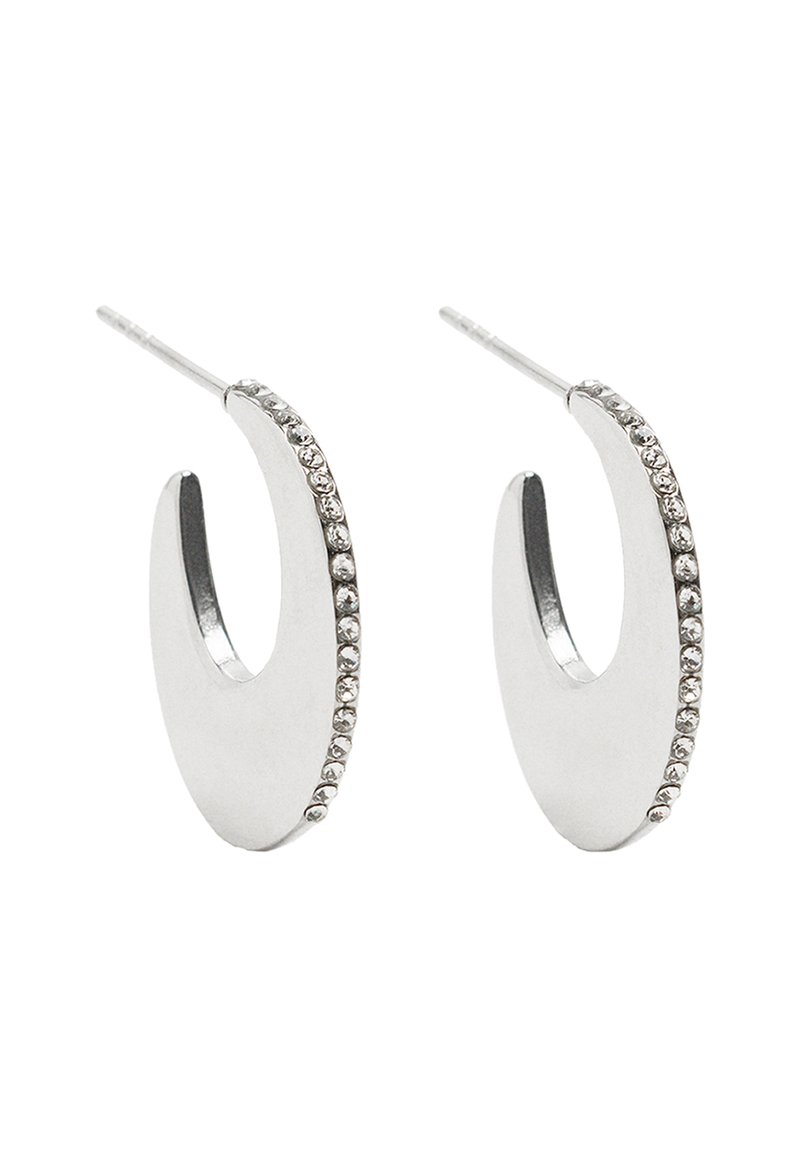 Srebrne kolczyki w kształcie obręczy o gładkim, zaokrąglonym wzorze, z rzędem małych przezroczystych cyrkoni wzdłuż jednej krawędzi.