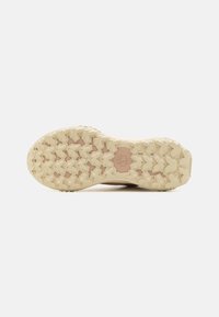 Helle Schuhsohle mit einem robusten Profil, das Kreuzformen für Traktion aufweist. Glatte Textur mit minimalem Logodetail.