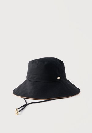 Must lai äärega ämbrimüts, millel on reguleeritav lõuarihm, mis lõpeb kuldsete helmeste ja paela peal oleva väikese metallist "BOSS" logoga.