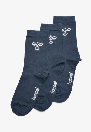 Granatowe skarpetki bawełniane z białym wzorem pszczół i logo "hummel". Charakteryzują się gładką fakturą i wysokością do kostki. Zestaw trzech par.