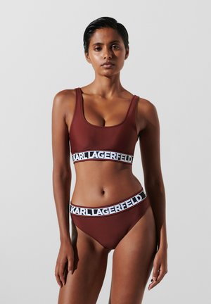 Brown swimwear set featuring a tank top with a wide branded band and high-waisted bottoms, both made of smooth fabric.