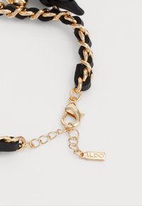 Black braided strap with gold metal chain links; features a gold lobster clasp and a small tag engraved with "ALDO."
