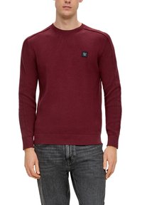 Burgunderfarbener Rundhalsausschnitt-Sweatshirt mit gerippten Bündchen und Saum, strukturiertem Strick, und einem kleinen schwarzen Logopatch auf der Brust.