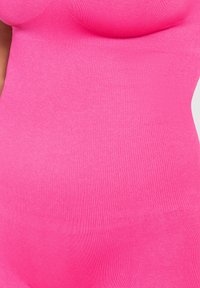 Fuchsia ärmlös topp med ribbad textur, med en figurnära design som formar sig efter kroppen. Inga ytterligare prydnader.