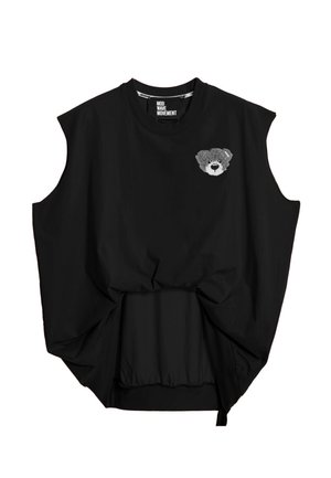 Top negro sin mangas con una pequeña cara de osito de peluche gris en el pecho izquierdo y un detalle anudado en la parte delantera.