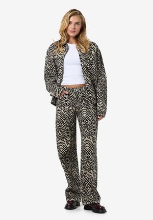Zebra-patterned jacket and pants set in beige and black, made from soft fabric. Jacket has a relaxed fit, paired with wide-leg trousers.