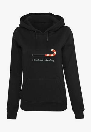 Hoodie noir avec une poche avant, des cordons de serrage et un graphique représentant une canne en sucre avec le texte "Noël en cours de chargement..." en blanc.