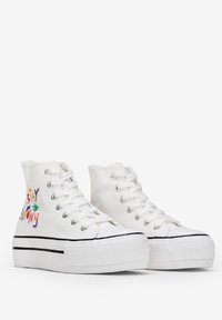 Sneakers alte bianche in tela con suola a piattaforma, caratterizzati da testo ricamato multicolore "Stay Sunny" e strisce orizzontali nere.